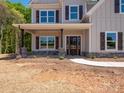 Inviting front porch with stone pillars and a dark wood door, perfect for welcoming guests to the beautiful home at 5311 Meadowland Pkwy, Monroe, NC 28112