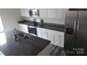 Kitchen with stainless steel refrigerator, stove, microwave, granite counter tops, and an island at 586 30Th Avenue Ne Cir, Hickory, NC 28601