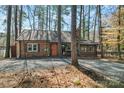 Quaint brick home with neutral trim, complemented by a gravel driveway and mature trees at 693 Emerald Shores Rd, Mount Gilead, NC 27306