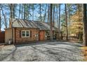 Cozy brick home with a gravel driveway, nestled in a wooded area with rustic charm at 693 Emerald Shores Rd, Mount Gilead, NC 27306