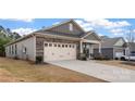 Single-Gathering home showcasing a two-car garage, stone accents, and a well-manicured front yard at 7127 Chrysanthemum Rd, Lancaster, SC 29720