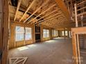An unfinished living room showing bare framing, a fireplace, and several windows allowing for natural light at 7459 Fighting Creek Rd # 33, Sherrills Ford, NC 28673