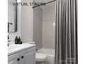 Bathroom with a shower-tub combo, grey tiled wall, updated vanity, modern fixtures, and a neutral color palette at 1001 Kensington Ave, Gastonia, NC 28054