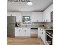 Well-lit kitchen featuring white cabinets, stainless steel appliances, granite countertops, and hardwood flooring at 1001 Kensington Ave, Gastonia, NC 28054