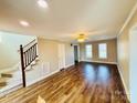 Spacious living room featuring hardwood floors, staircase, ceiling fan and large windows at 1146 Crestmont Se Dr, Concord, NC 28025