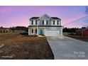 Two story home with grey and white siding, shutters, a blue front door, and a two car garage at 147 Stanfield Farm Ln, Stanfield, NC 28163