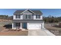 Two story home with grey and white siding, shutters, a blue front door, and a two car garage at 147 Stanfield Farm Ln, Stanfield, NC 28163