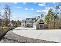 View of the gray, two-story home featuring a three-car garage and concrete driveway leading to the home at 154 Fox Hunt Dr, Mooresville, NC 28117