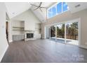 Open living room with fireplace, vaulted ceiling, hardwood floors and sliding doors to a large deck at 154 Fox Hunt Dr, Mooresville, NC 28117