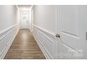 Bright hallway featuring hardwood floors, crisp white trim, and a classic paneled front door at 2058 Skyhawk Dr, Lake Wylie, SC 29745
