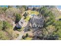 Aerial view featuring a stone clad home with a detached garage, a pool, and manicured landscape at 20711 Bethel Church Rd, Cornelius, NC 28031