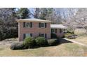 Charming brick home with green shutters, complemented by mature landscaping and a well-manicured lawn at 2105 Monticello Dr, Gastonia, NC 28056