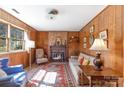 Cozy living room with wood-paneled walls, a brick fireplace, and traditional decor for a warm atmosphere at 2105 Monticello Dr, Gastonia, NC 28056