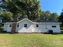 The back exterior of this quaint single-story home features a well-maintained lawn and classic architectural details at 345 Mountain View St, Gastonia, NC 28052