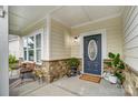 Inviting front porch with stone accents, decorative plants, and a cozy seating area at 5006 Sand Trap Ct # 142, Monroe, NC 28112