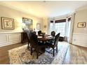 Elegant dining room with wainscoting, a round table, and a bay window with a serene view at 6301 Royal Aberdeen Ct, Charlotte, NC 28277