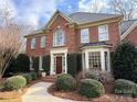 Charming brick home featuring manicured shrubs, a brick walkway, and a classic architectural design at 6301 Royal Aberdeen Ct, Charlotte, NC 28277