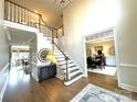 Grand foyer with a sweeping staircase, hardwood floors, and views into the formal dining room at 6301 Royal Aberdeen Ct, Charlotte, NC 28277