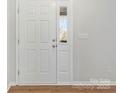 Bright entryway featuring white six panel door with half light and wood-look laminate flooring at 733 Rocky Grove Gln, York, SC 29745