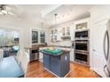 Bright kitchen with white cabinets, stainless steel appliances, a center island and a view to the outdoor deck at 7732 Wingmont Dr, Charlotte, NC 28269