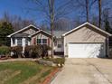 Charming single-story home with manicured lawn, tidy landscaping, and attached two car garage at 7936 Rolling Stone Ave, Charlotte, NC 28216