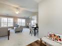 Bright living room boasts vaulted ceiling, a ceiling fan, large windows, and adjacent dining area at 7936 Rolling Stone Ave, Charlotte, NC 28216