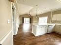Open concept living area featuring a kitchen with white cabinets and a spacious breakfast bar area at 8668 Coralbell Ln # 10, Charlotte, NC 28213