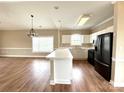 Spacious kitchen featuring a breakfast bar, white cabinets, and modern black appliances at 8668 Coralbell Ln # 10, Charlotte, NC 28213