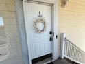Charming front door with wreath, address number, and modern lock at 8668 Coralbell Ln # 10, Charlotte, NC 28213
