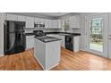 Well-lit kitchen with granite countertops, white cabinets, and modern black appliances at 9014 Arbor Creek Dr, Charlotte, NC 28269