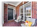 Inviting front porch featuring brick flooring, neutral chairs with patterned pillows, and a welcoming entrance at 108 Berkshire Ave, Belmont, NC 28012