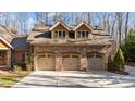 This spacious three-car garage features stone accents and carriage doors, perfect for car enthusiasts at 11280 Mcfalls Dr, Fort Mill, SC 29707