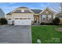 Inviting home with a well-maintained lawn, stone accents, and a two-car garage at 2112 Balting Glass Dr, Indian Trail, NC 28079