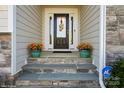Charming front door with stone steps and decorative plants in matching green pots at 2112 Balting Glass Dr, Indian Trail, NC 28079