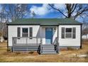 Cozy single-story home featuring a light-colored exterior, gray porch and a vibrant blue front door at 2123 Ravendale St, Kannapolis, NC 28083