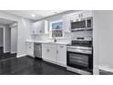 Modern kitchen with sleek stainless steel appliances, white cabinetry, and dark hardwood floors at 2123 Ravendale St, Kannapolis, NC 28083