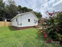 The property has a new fence, manicured lawn and garden, and classic white siding at 2328 Milton Ave, Gastonia, NC 28052