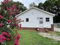 Charming home with a well-maintained lawn, beautiful flowering shrub, and classic white siding at 2328 Milton Ave, Gastonia, NC 28052
