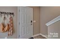 Entryway with a white front door, decorative 'WELCOME' sign, and neutral-toned walls at 3060 Ora Smith Rd, Lincolnton, NC 28092