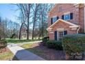 Brick townhome featuring manicured landscaping and an adjacent grassy field at 4151 Ivystone Ct, Charlotte, NC 28277