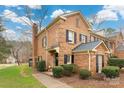 Beautiful brick townhome with a chimney, green grass, and black shutters at 4151 Ivystone Ct, Charlotte, NC 28277
