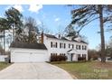 Traditional home with a well-manicured lawn, two-car garage, and a classic white facade at 7201 Brassy Creek Ln, Charlotte, NC 28269