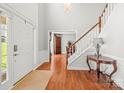 Bright foyer with hardwood floors, a staircase, and classic décor creates an inviting entrance at 8802 Glenside St, Huntersville, NC 28078