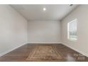 Bright, empty room featuring hardwood floors, natural light from a window, and a neutral color palette for personalization at 920 Clementine Rd, Monroe, NC 28110
