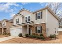 Two-story home boasts a two-car garage, brick and siding accents, a welcoming entrance, and neatly maintained landscaping at 920 Clementine Rd, Monroe, NC 28110