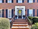 Welcoming brick front porch with wrought iron railings and a black front door with sidelights at 11309 Brittany Oaks Dr, Charlotte, NC 28277