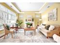 Inviting living room with tray ceilings, fireplace, large windows, and neutral decor, perfect for relaxation at 1209 Waypoint Ct, Matthews, NC 28104