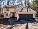 Inviting home featuring a spacious two-car garage, complemented by a lush, natural landscape at 1590 Daybreak Ridge Rd, Kannapolis, NC 28081