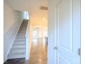 Bright foyer featuring wood floors, a staircase, and an open view of the living space at 203 Makayla Ct, Fort Mill, SC 29715