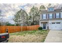 Inviting front yard with a wood fence and partial view of the two-story townhome at 203 Makayla Ct, Fort Mill, SC 29715